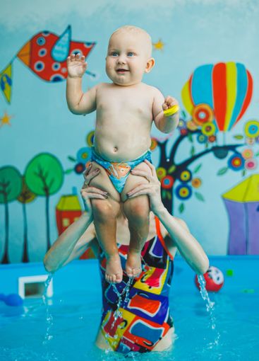 Baby boy swimming in the pool. Swimming pool for babies...