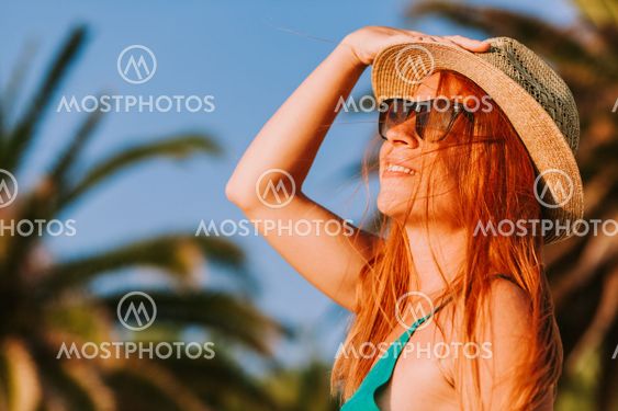 Young woman enjoying the view by the palm trees