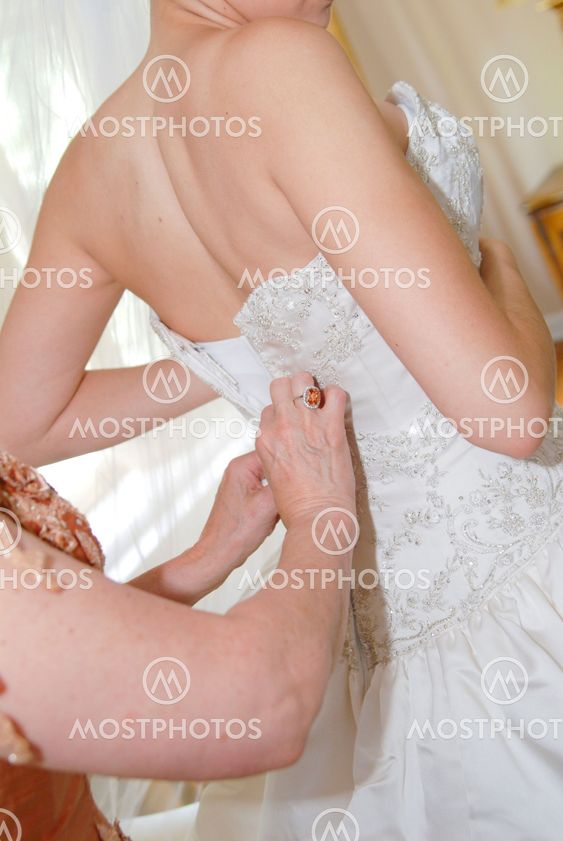 Bride dressing for the wedding ceremony