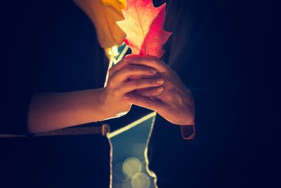 Couple holding autumnal red leaf. Vintage mood photo