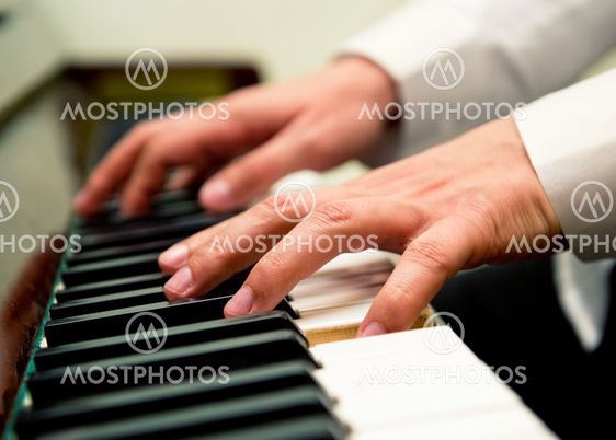 Male hands playing the piano