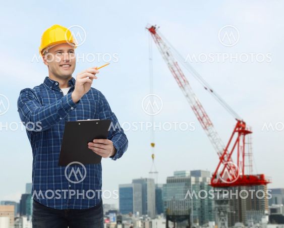 smiling male builder in helmet with clipboard