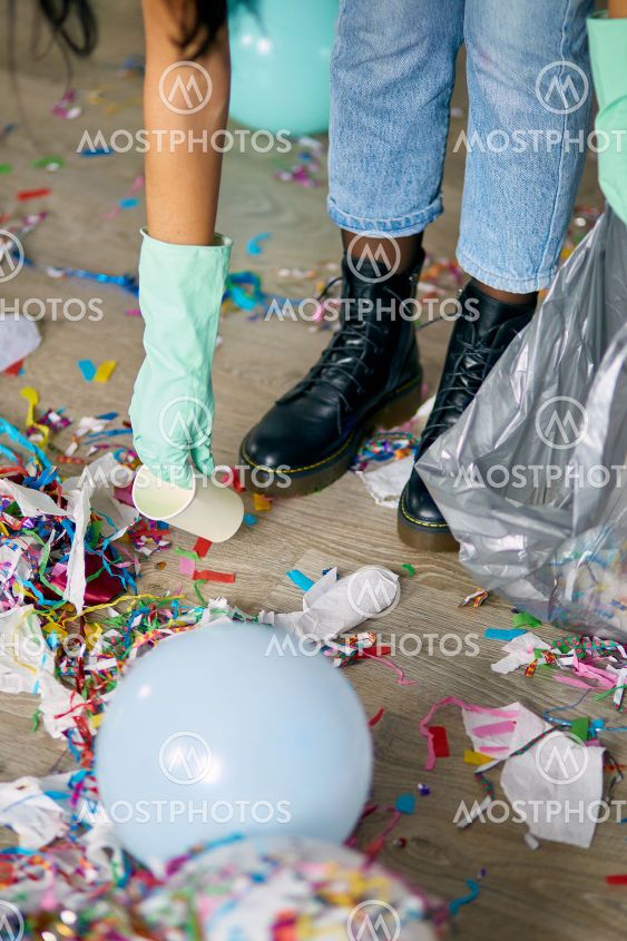 Woman with pushbroom cleaning mess of floor in room