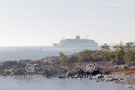 Large ferry partly hidden in fog, cliffs and trees