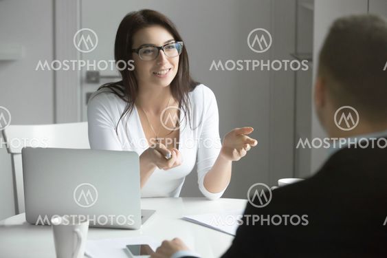 Businesswoman talking to a man at the desk