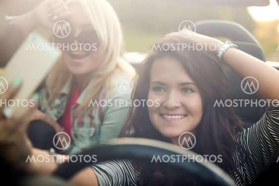 Girlfriends taking selfie in car