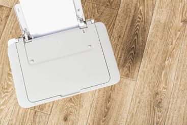 Printer on a wooden floor for home office use with blank...