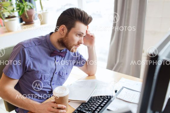 creative male worker with computer drinking coffee