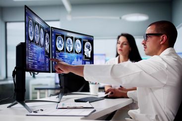 Doctors In Clinic Looking At Brain MRI Scan