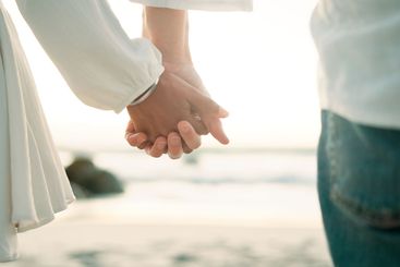Holding hands, love and closeup with couple at beach for...