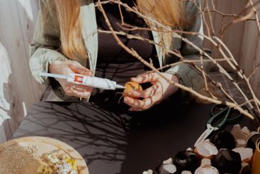 Unrecognizable woman creating Easter holiday decoration...