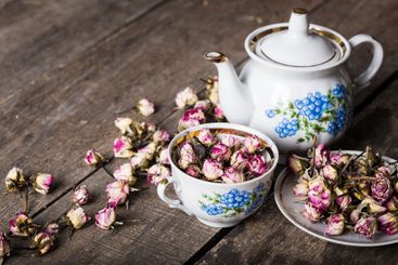 Vintage teapot and cup with blooming tea flowers on...