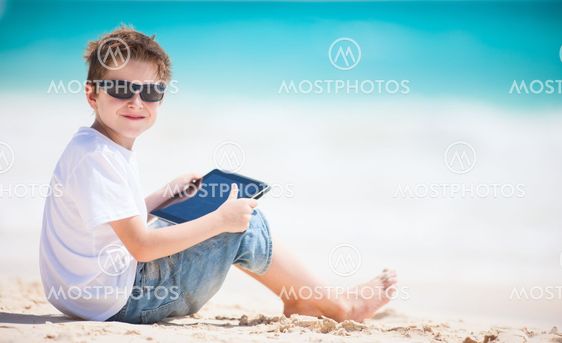Boy with tablet device at beach