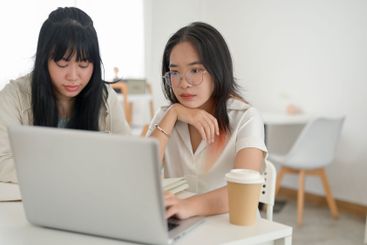 A young, serious Asian woman is concentrating on her...