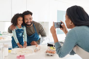 Parents, daughter and baking picture in kitchen for...