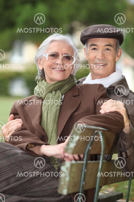 A mature couple on a bench.