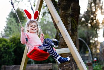 Happy beautiful little toddler girl with red Easter...
