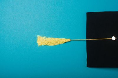 Top view of black graduation cap with yellow tassel on...