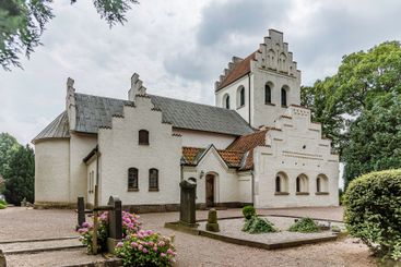 a whitewashed stone church with stepped gables in Skåne...