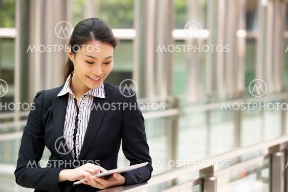 Chinese Businesswoman Working On Tablet Computer Outside Office