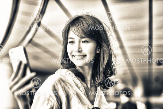 Beautiful japanese woman looking at smartphone inside...