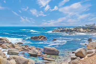 Rocks, ocean and waves on horizon, sky and clouds with...
