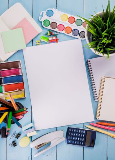 Creative workspace filled with colorful art supplies and...