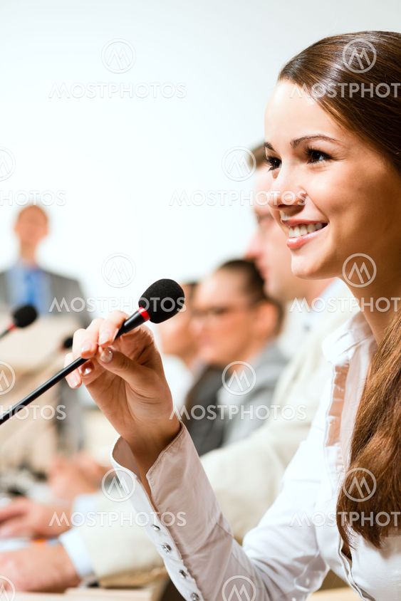 Business woman speaks into a microphone
