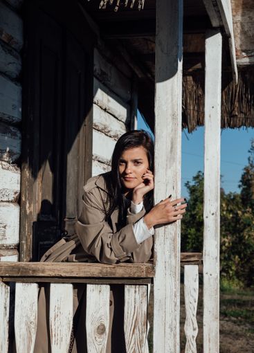 Beautiful brunette woman in gray coat at the door on the...