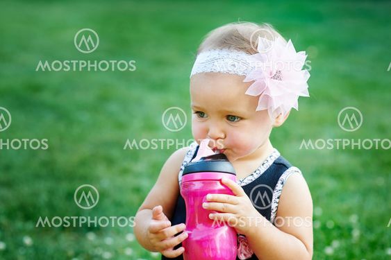 Happy Little girl playing in summer meadow on grass