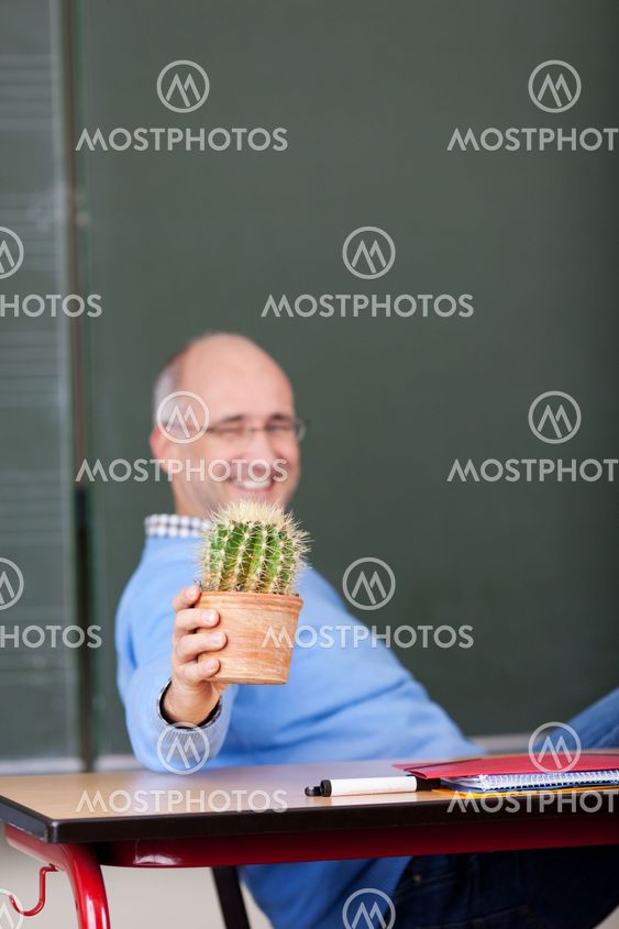 Professor Showing Cactus Plant At Desk