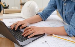 Architect and engineer working on blueprints using a...