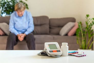 An old woman measures her blood pressure. Selective focus.