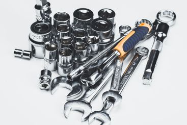 Assorted hand tools and sockets arranged on a flat...