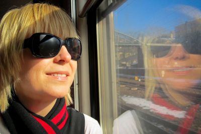 Kvinna med solglasögon åker tåg