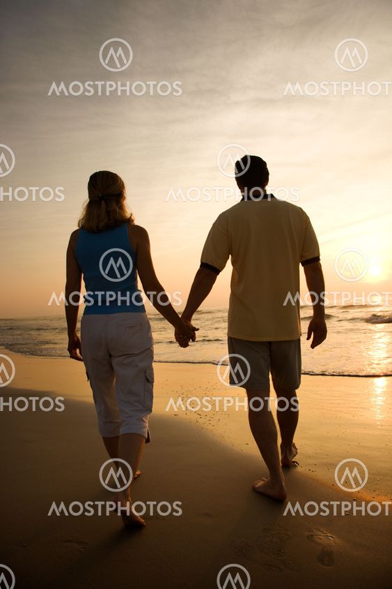 Couple on beach at sunset.