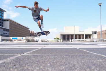 Man, jump or challenge with skateboard in city for...