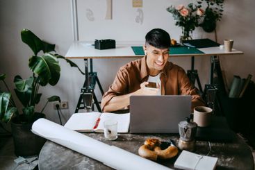 Smiling male business professional talking through smart...