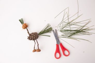 A handmade bird crafted from pine cones and twigs, a...