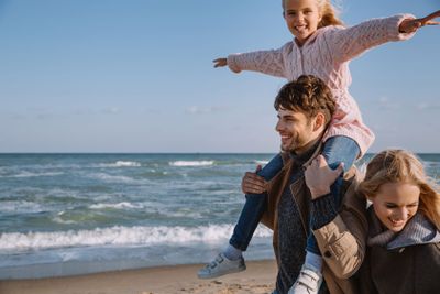 family with happy daughter on seashore