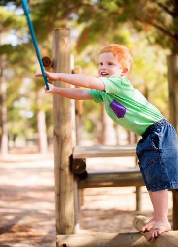 Smile, kid and rope at playground park for fun game,...