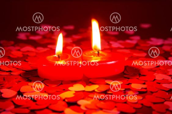 Burning heart shaped candle over red background, Stock image