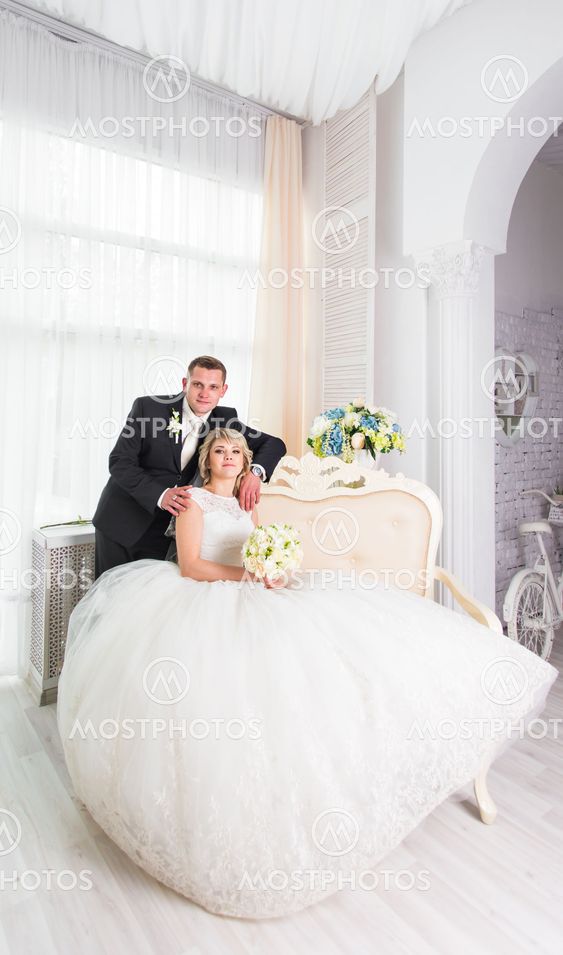 Wedding couple indoors is hugging each other. Beauty...