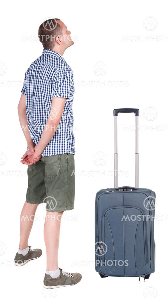 Back view of young man traveling with suitcas.