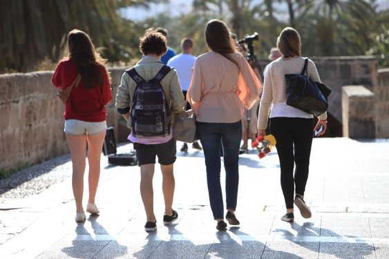 Rear view of four students walking away