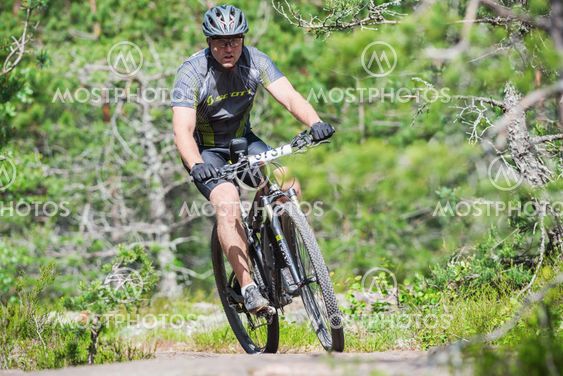 Man on mountain bike out of a curve in the forest at Lida...