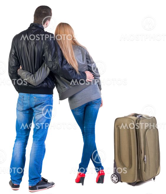 Back view of young couple traveling with suitcas .