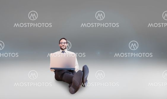 Composite image of businessman using laptop