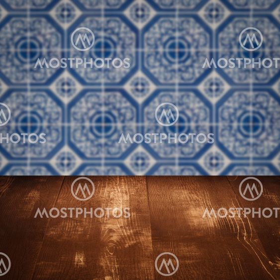 Wood table top and blur vintage ceramic tile pattern wall