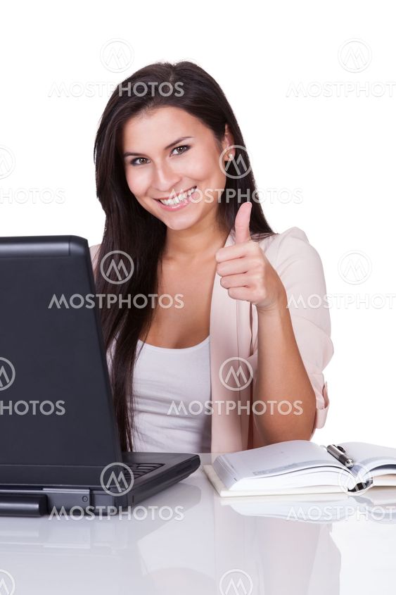 Woman sitting at laptop giving a thumbs up